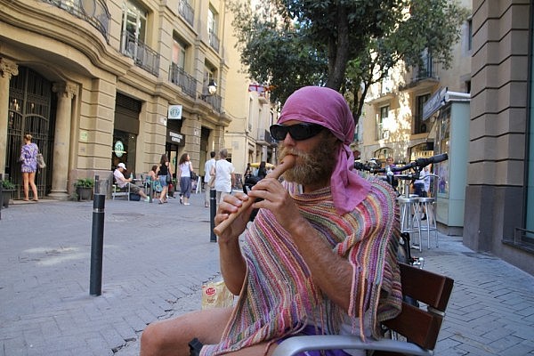 Disguised as a hippie and playing flute in Barcelona